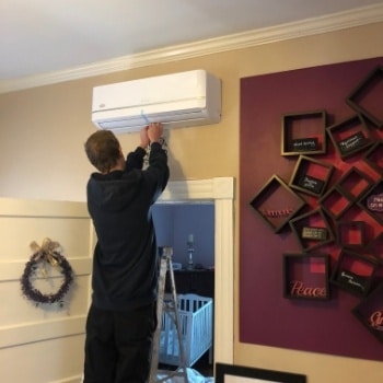 Worker installing ductless unit